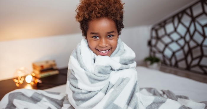 criança com cobertor sorrindo
